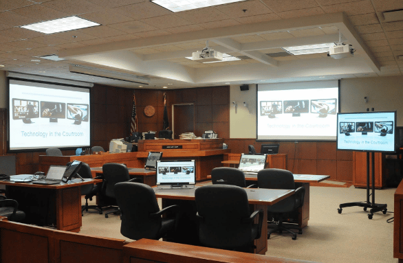 Image shows courtroom with screens for info to be shown.