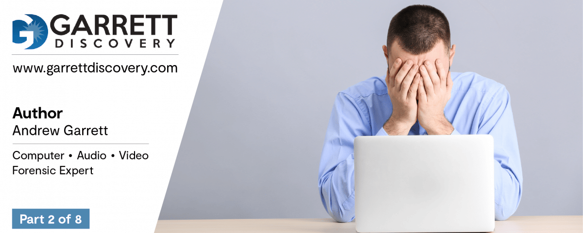 Man with face in hands behind computer